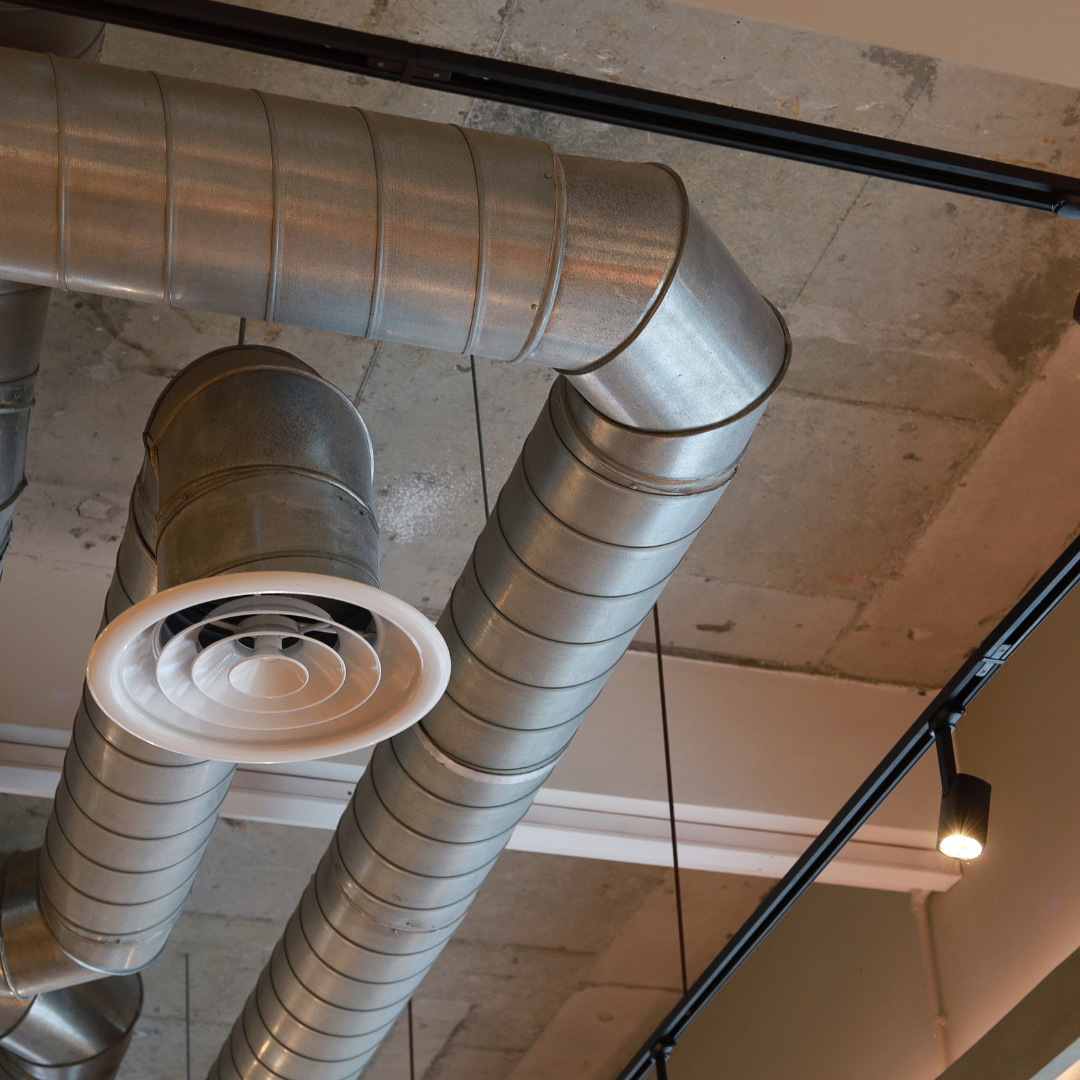 Exposed ductwork and ventilation equipment inside a commercial building, representing heating, cooling, and airflow systems as part of energy management.