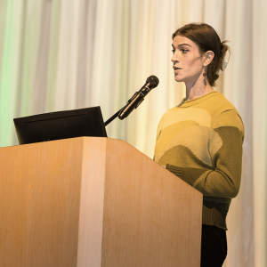 An IMPACT Pitch finalist presents their business from the podium during the live competition.