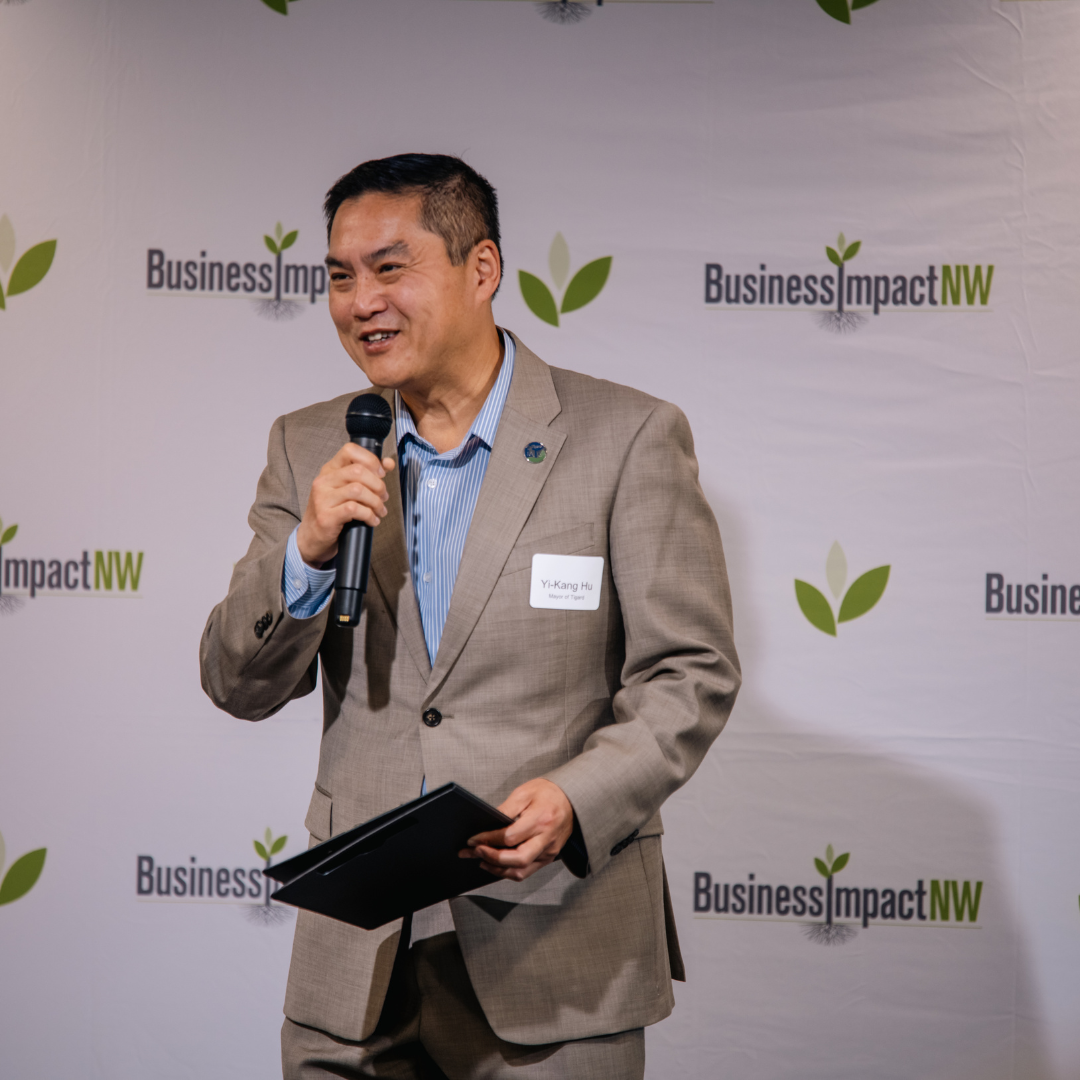 Tigard Mayor Yi-Kang Hu speaks into a microphone during Oregon Small Business Connections.